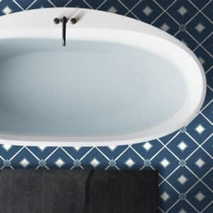 Bathroom with blue and white patterned vinyl floor beside freestanding bath